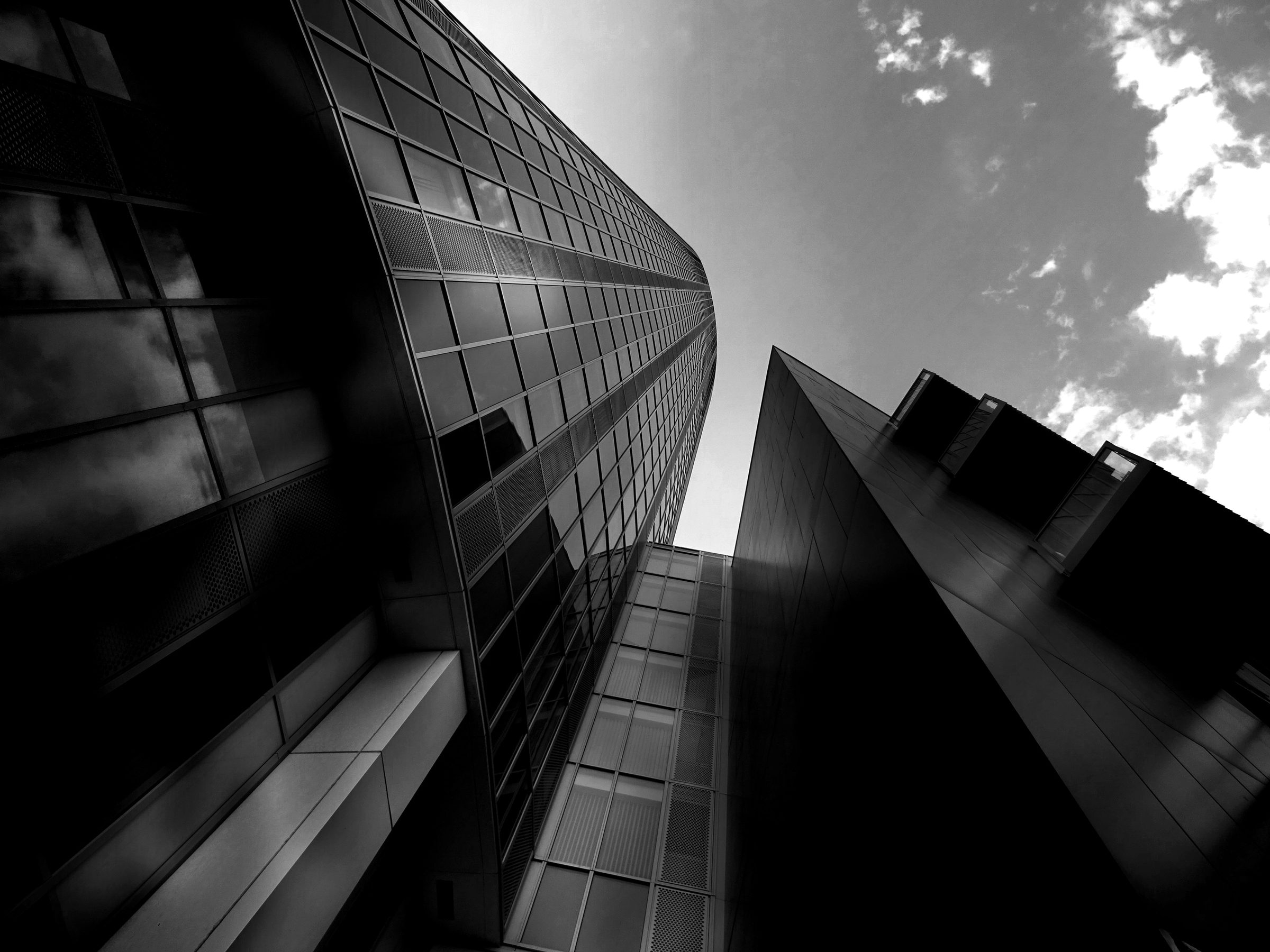Torres corporativas de vidro vistas de baixo, em preto e branco