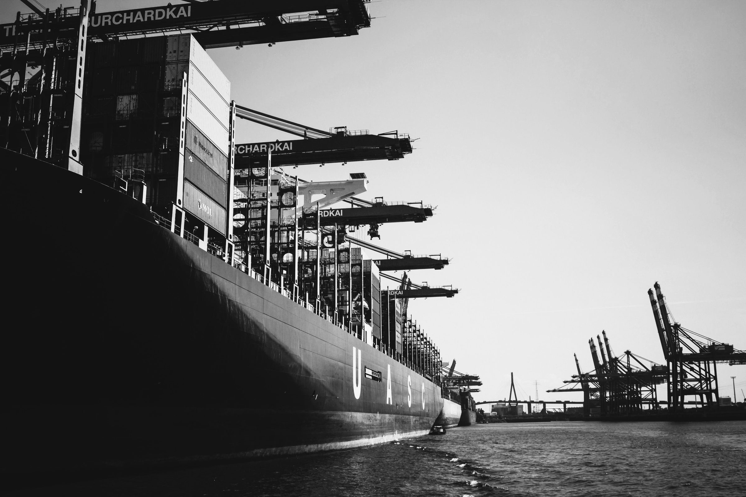 Navio porta-contêineres atracado em terminal portuário, em preto e branco